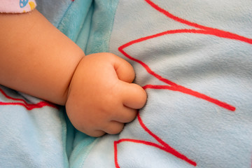 Asian baby hand on a soft bed