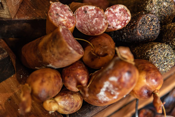 Variety of processed cold meat products with condiments. Assortment of different cold meats in a basket