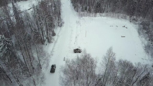Military APC in the woods during military exercises. Clip. Top view of military armored personnel carriers in the forest in winter