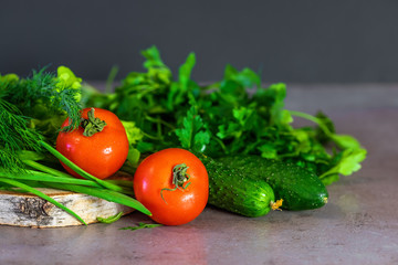 Fresh vegetables and greens for salad on a wooden surface. The concept of a healthy diet.
