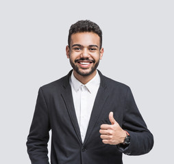 Portrait of handsome smiling young man showing thumb up gesture. Laughing joyful cheerful men...