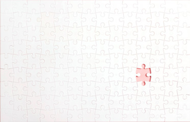 White puzzle pieces with one lost piece.