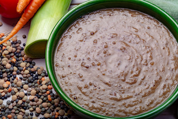 Tasty vegetarian food, green bowl with lentils soup with vegetables, good for vegans