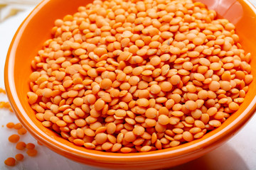 Dried orange lentils legume in orange bowl