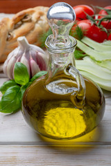 Virgin natural olive oil is glass bottle, served with traditional Mediterranean food