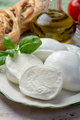 Obraz na płótnie Canvas Balls and pieces of buffalo mozzarella, soft Italian scheese made from the milk of Italian Mediterranean buffalo