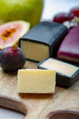 Mini black and dark red waxed cheddar cheeses made from West Country milk and and age-old methods in England