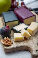 Mini black and dark red waxed cheddar cheeses made from West Country milk and and age-old methods in England