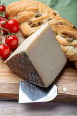 Italian cheese, piece of mature Tuscan Pecorino sheep cheese served with olive bread and tomatoes