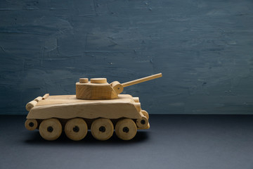 Wooden tank on blue painted background. Wooden toy tank studio shot.