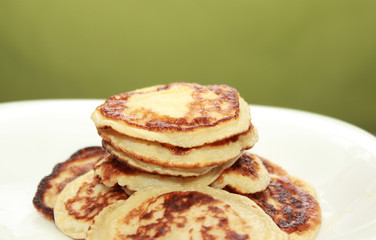 Cottage cheese pancakes or curd fritters decorated powdered sugar in plate close view. Healthy and diet breakfast