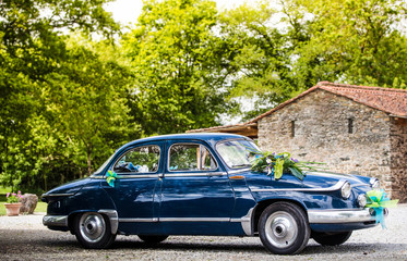 Blue old car in the middle of a countryside scenery