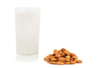 Glass of almond milk with heap of nuts isolated on white.