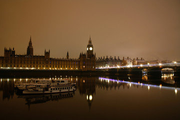 Fototapeta na wymiar Snow covered Westminster Palace at dawn over dark grey sky