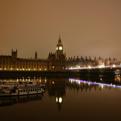 Fototapeta na wymiar Snow covered Westminster Palace at dawn over dark grey sky