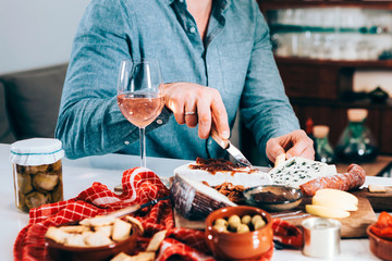 closeup of male hands picking up food with wine. gourmet, tasty, tapas, aperitif concept