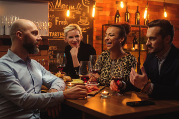 Group of friends having fun talk behind bar counter in a cafe