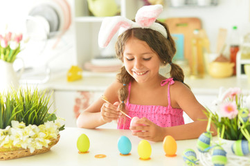Portrait of cute girl decorating eggs for Easter holiday