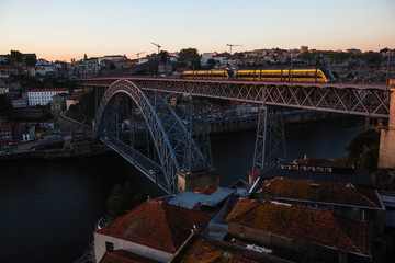 View of the Luis I Iron bridge with train over the Douro river at dusk, Porto - Portugal.