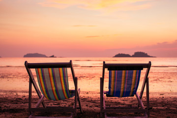 Sun loungers on the sea beach during sunset.