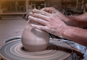 Potter make a clay bowl on a potter wheel at Koh Kret Pottery Village and Brewery, Pak Kret District, Nonthaburi,Thailand.