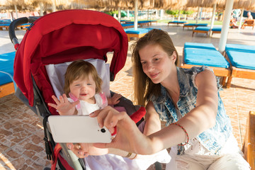 Mother and daughter making selfie on resort