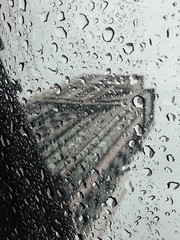 Rain drops on the car sunroof with blur building view background.