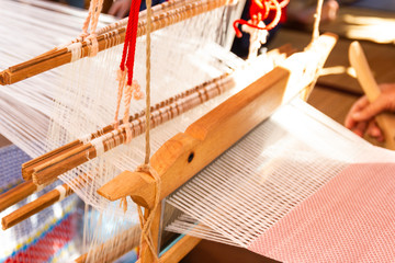 Fototapeta na wymiar Weaving equipment Household weaving - Detail of weaving loom for homemade silk Used for silk weaving or textile production of Thailand 