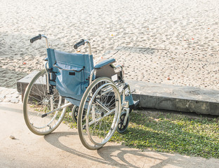 A wheelchair sits on the beach.