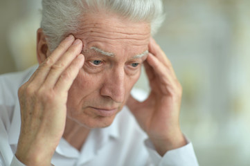 Close-up portrait of senior man with headache