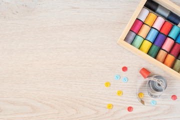 Composition with sewing threads and accessories on gray wooden background, top view