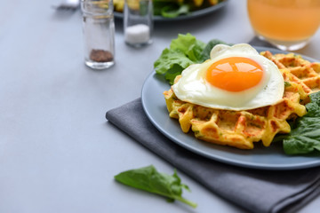 Spinach cheese waffles with fried egg on gray wooden background. Selective focus.
