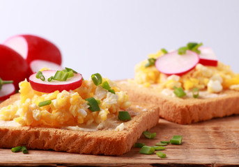 Scrambled eggs with radish and chives on crunchy toasted bread
