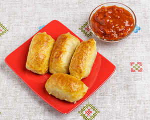 Pastries and sauce on a plate on a napkin.