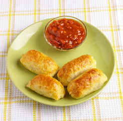Pastries and sauce on a plate on a napkin.