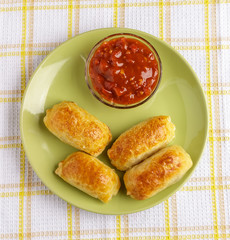 Pastries and sauce on a plate on a napkin.