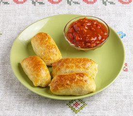 Pastries and sauce on a plate on a napkin.