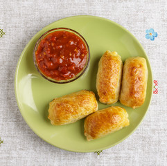 Pastries and sauce on a plate on a napkin.