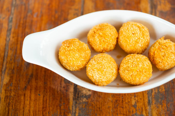 cheese balls in white plate on wooden table