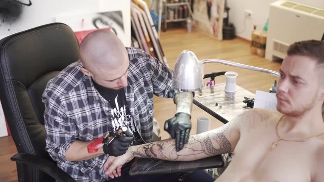 Tattoo master makes a tattoo in the salon.