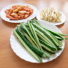 Some ingredients for sushi rolls -  cucumbers, feta cheese, salmon