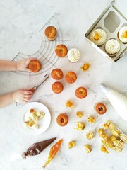 The process of cooking and decorating cupcakes top view. Children's hands in the frame.