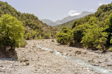 Fototapeta na wymiar The mountains and the river Kalarrytikos (Greece)on a sunny summer day.