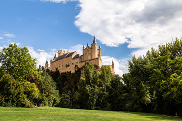 Fototapeta na wymiar The famous view of the Alcazar of Segovia in a sunny summer day from the view point of la Pradera de San Marcos, Segovia, Castilla y Leon, Spain
