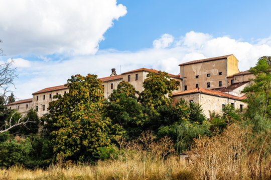 Yellow grass, red tree and old houses near the eresma river at end of Summer, Segovia, Castilla y Leon, Spain