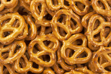 Lot of whole mini salted pretzels stack flatlay as abstract background. Copy space for your text.