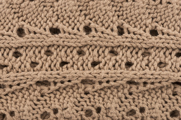 Close up on a beige knitted sweater as the background. Fashion design. Macro.