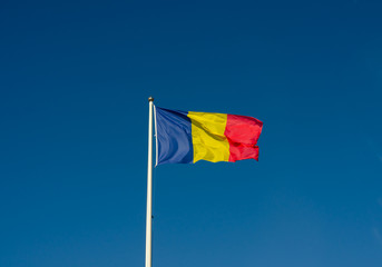 Low angle view of Romania flag  agains  blue sky.