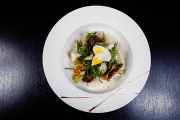 Salad with egg, red pepper, cheese and tomato served on a plate.