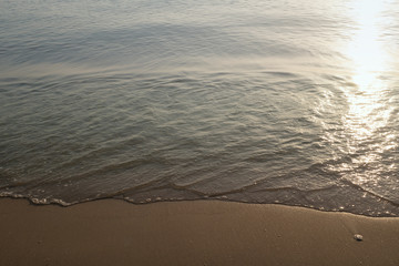 Nature background of beach wave and coastline sand with sunlight water surface